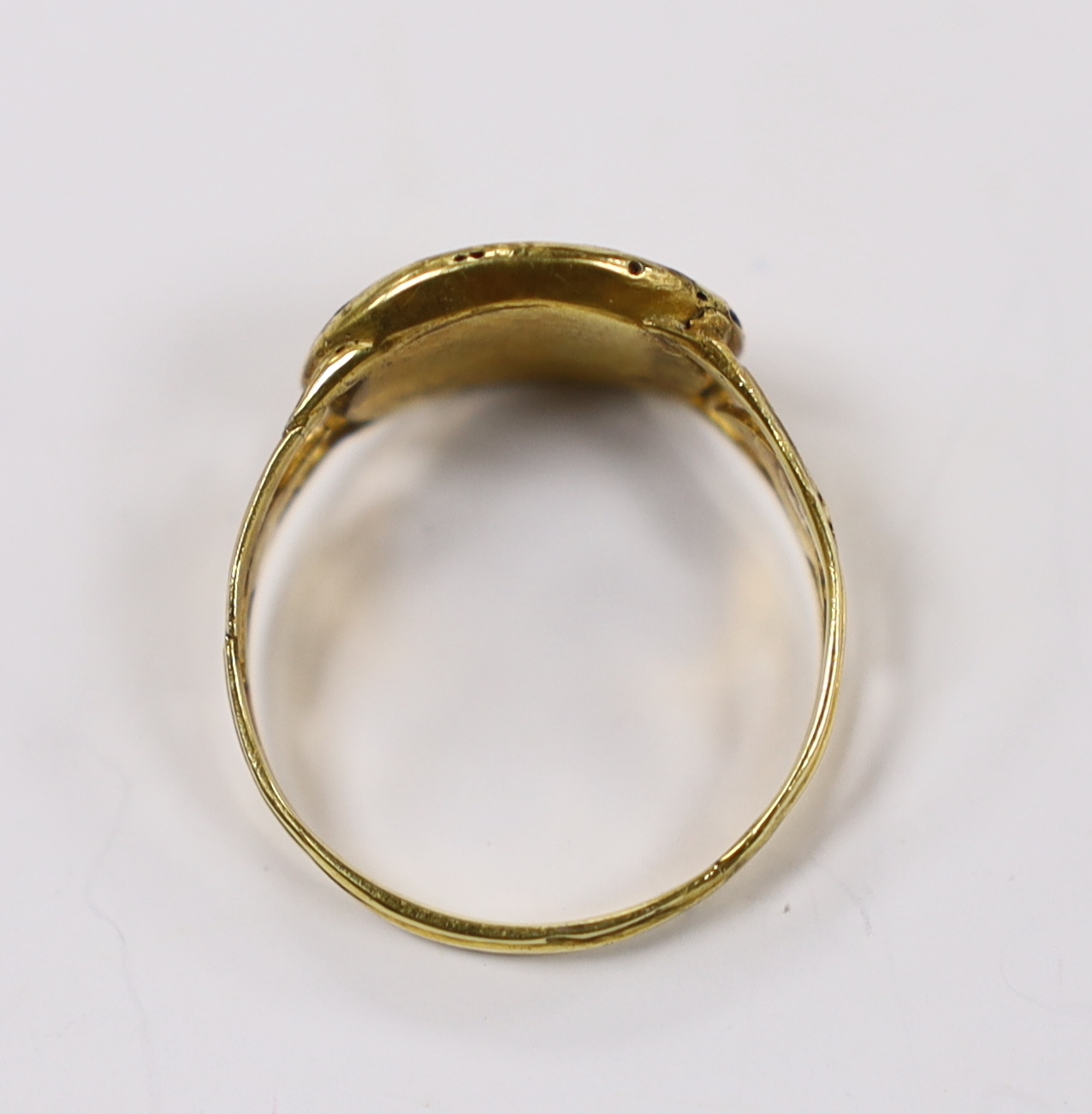An early 19th century two colour yellow metal mourning ring, with glazed panel and pierced foliate shoulders, size R, gross weight 2.4 grams.